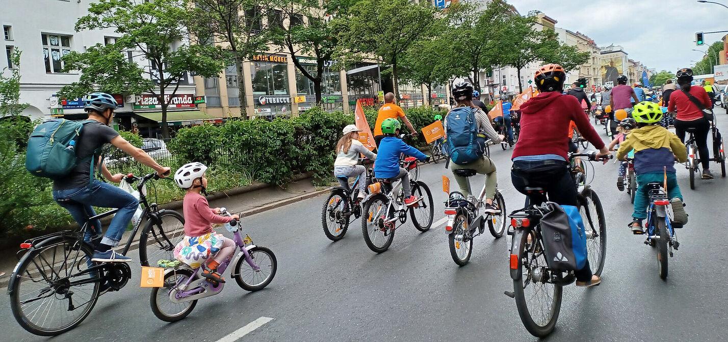 Glückliche Kinder radeln bei der KidicalMass über große Straßen