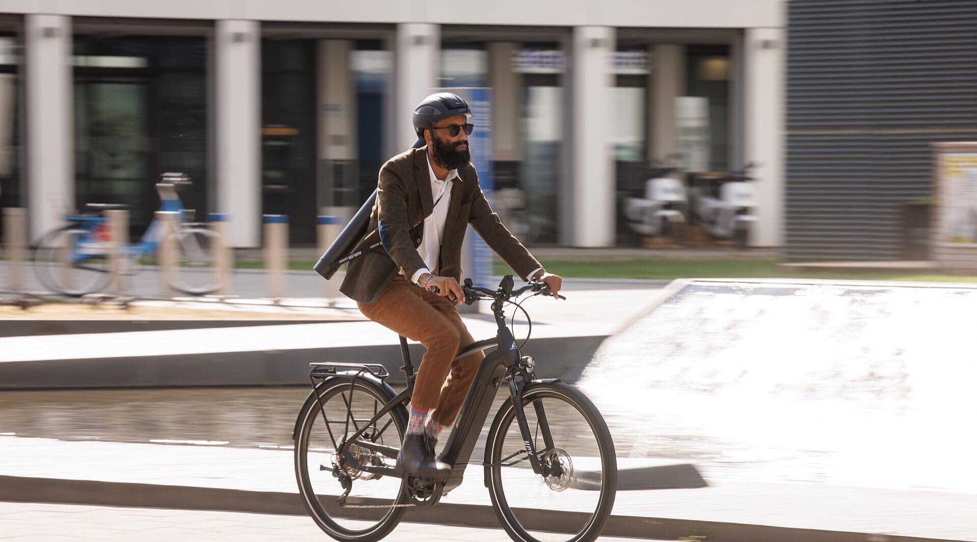 Ein Pendler fährt auf seinem elektrischen Fahrrad durch das Stadtgebiet. 