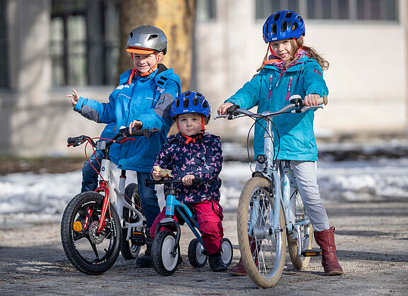 Kinder unterschiedlichen Alters auf dem Rad Drei Kinder in unterschiedlichem Alter auf Fahrrädern.