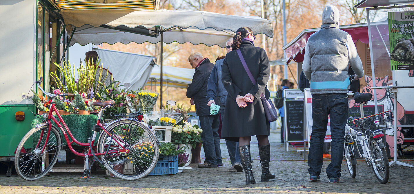 Marktszene mit Fußgängern und geparkten Fahrrädern