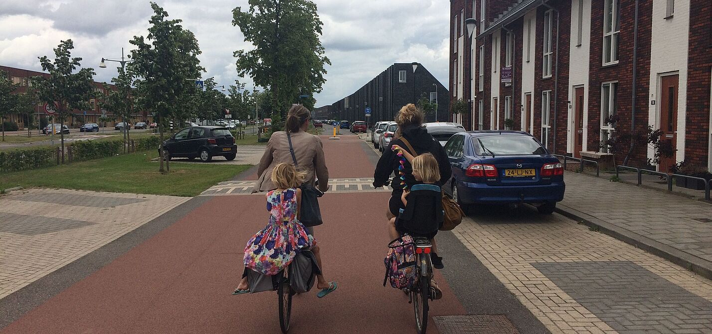 Zwei Frauen mit Kinder auf dem Rad auf einem breiten, separierte Radweg in den Niederlanden