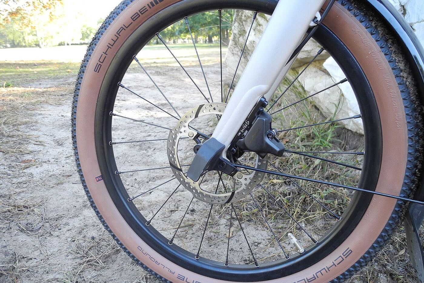 Großaufnahme des Brompton-Vorderrades mit der Scheibenbremse im Vordergrund. 