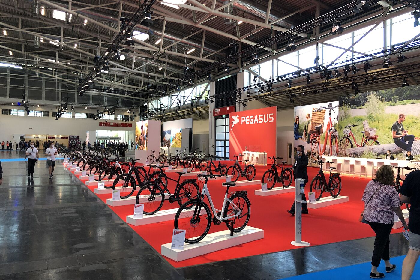 Eine Ausstellungshalle auf der IAA mit Fahrradherstellern und wenigen Besuchenden.  